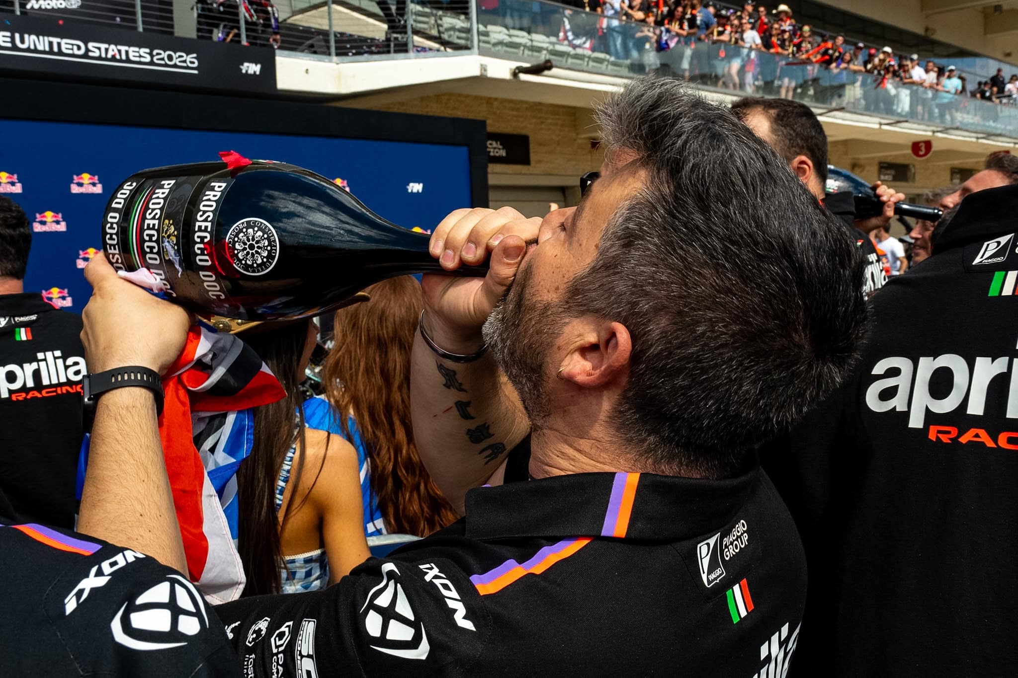 Aprilia team member drinking from 3 liter bottle.
